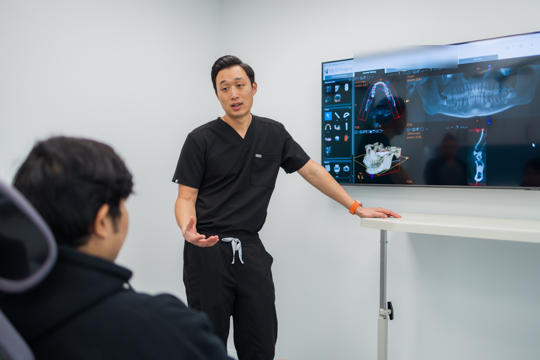 Dr. Daniel Yang reviewing 3D dental imaging with a patient
